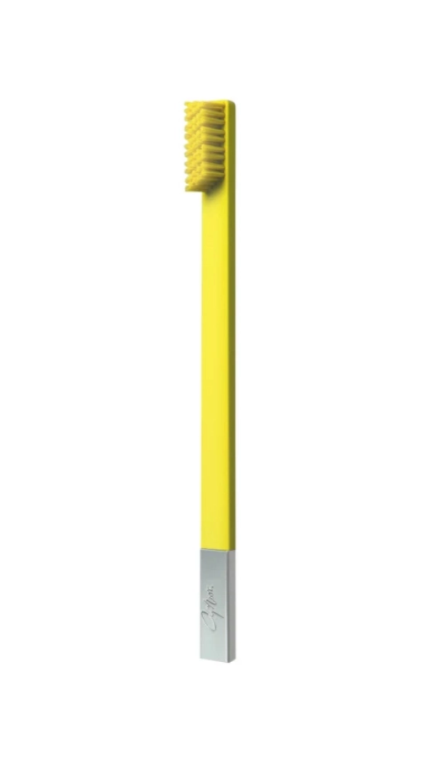 A sunflower yellow and silver soft toothbrush with a manual handle and a brush head.