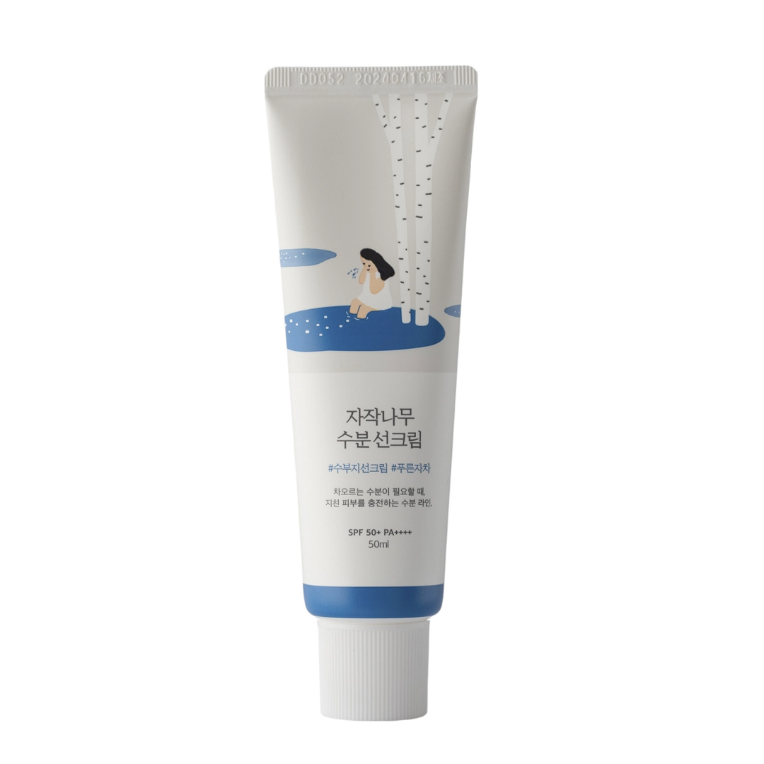 A tube of Round Lab moisturizing sun cream with Birch Juice, providing SPF50+ PA++++ protection. The packaging is primarily white with a blue graphic of a girl and birch trees.