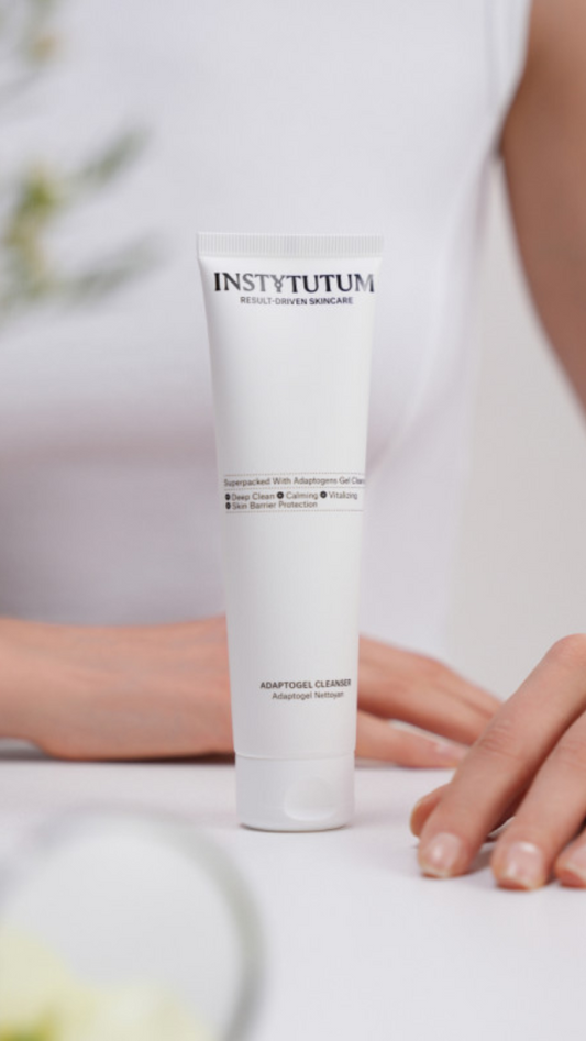 Tube of Instytutum skincare product on a white surface with blurred background