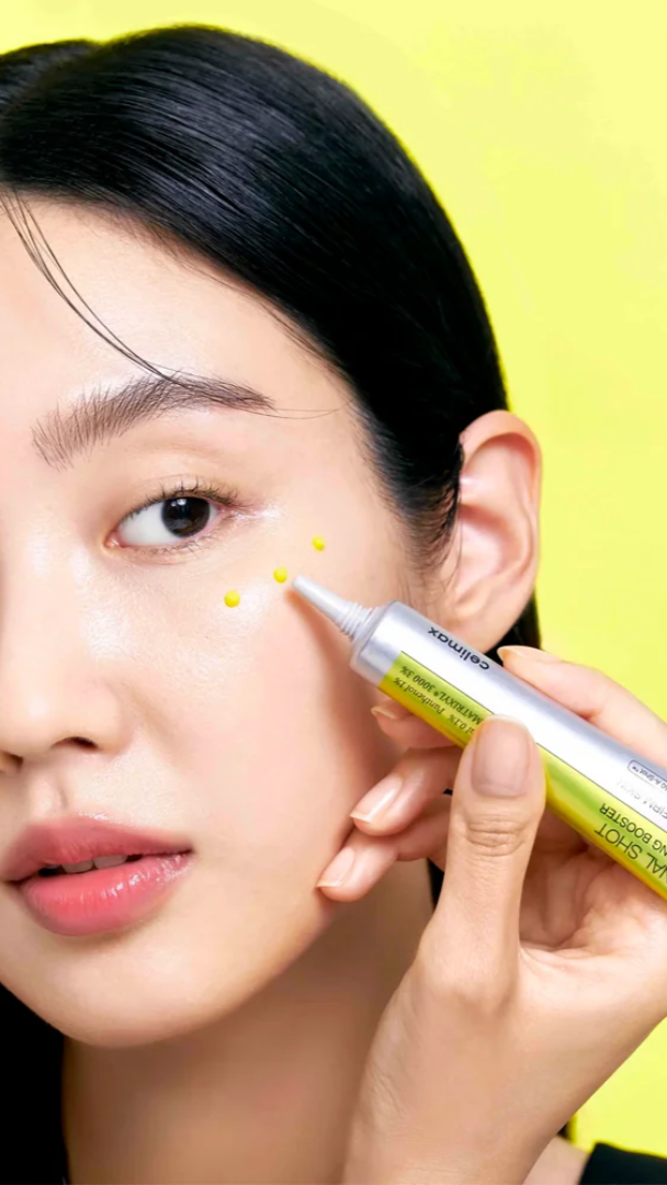 Person applying a cosmetic product to their face with a yellow background