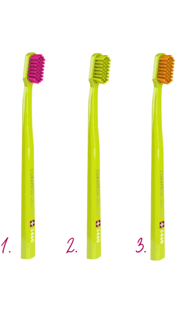 Three green toothbrushes with different bristle colors on a white background