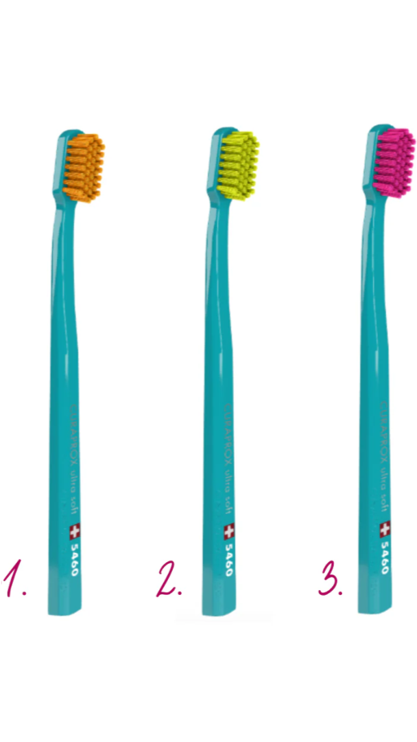 Three toothbrushes with different colored bristle heads on a white background