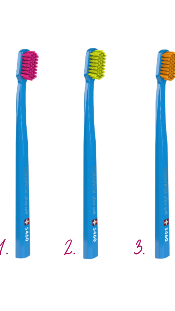 Three blue toothbrushes with colored bristles on a white background