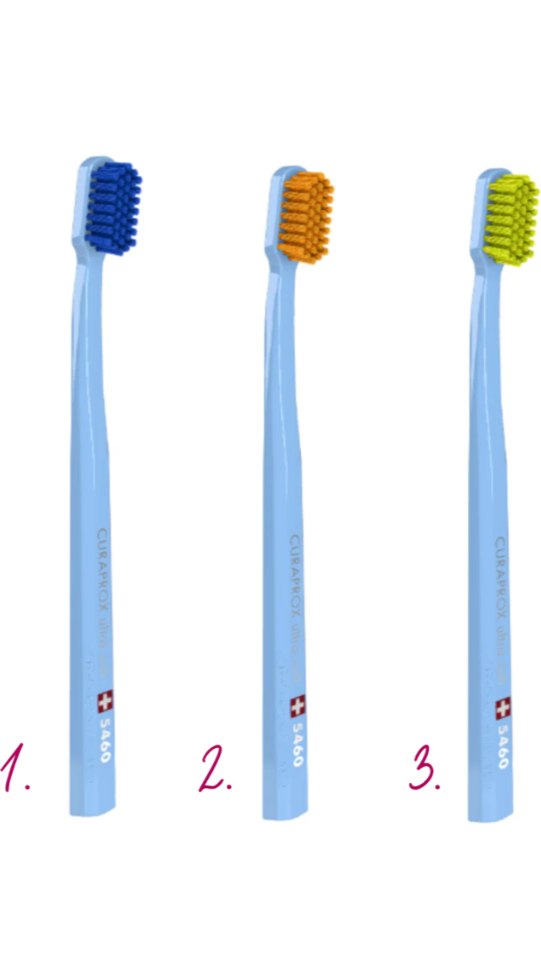 Three blue toothbrushes with different colored bristle heads on a white background