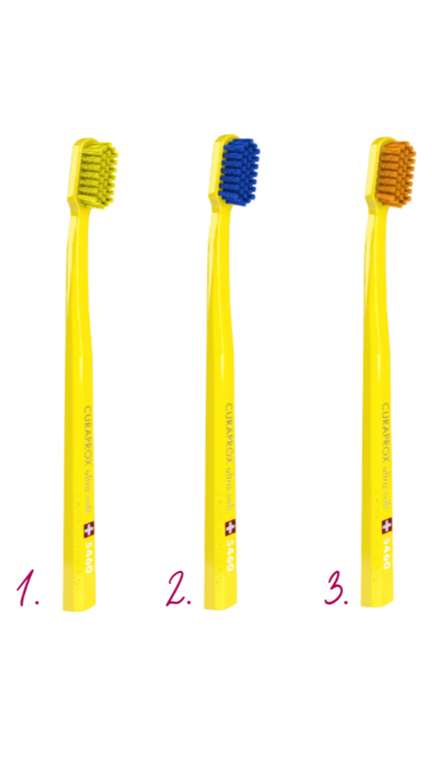 Three yellow toothbrushes with different bristle colors on a white background