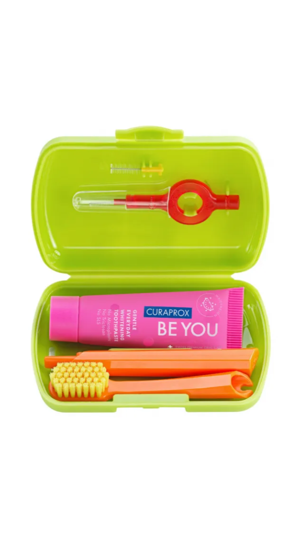 Green travel dental kit with toothbrush, toothpaste, and floss on a white background