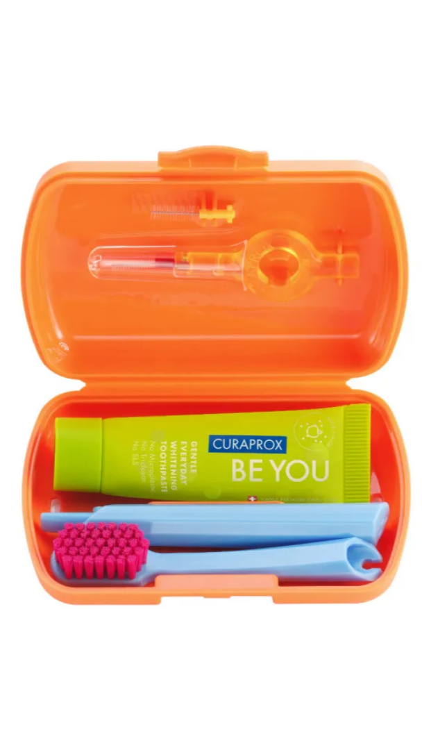 Orange travel dental kit with Curaprox toothpaste and tools on a white background