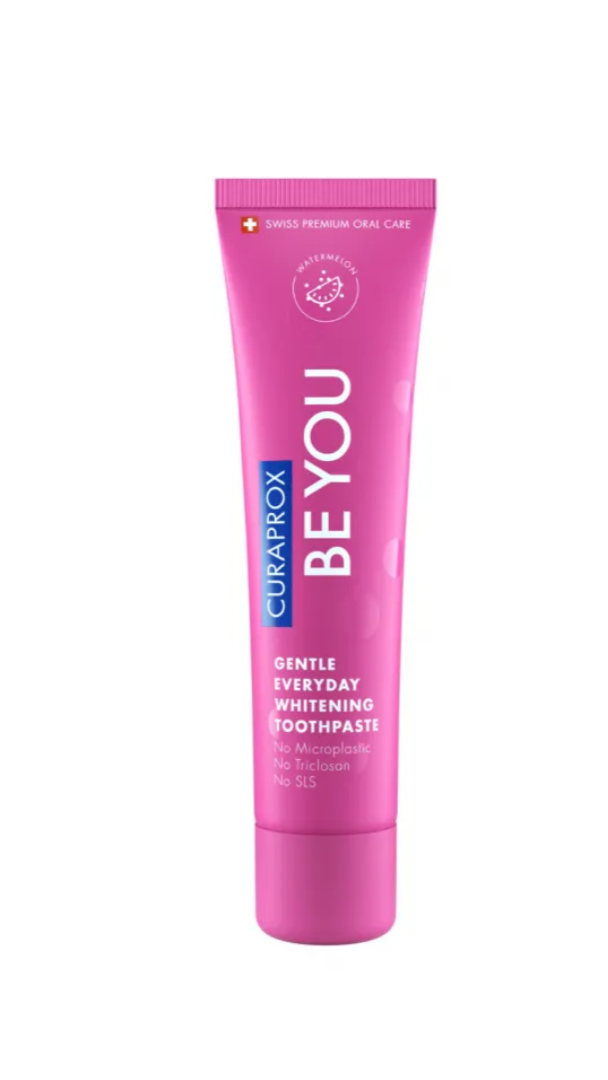 Pink toothpaste tube labeled 'BE YOU' by Curaprox on a white background